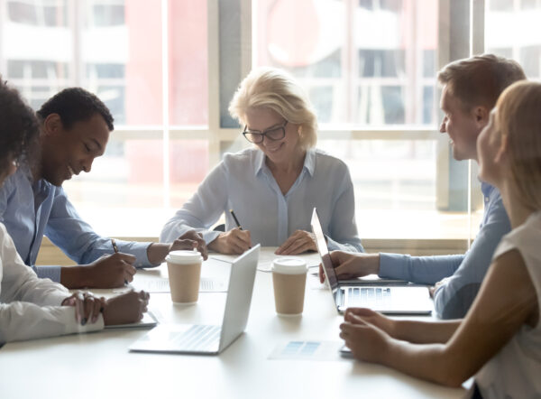 Diverse business partners sign two contracts at group meeting, businessman and businesswoman deal parties write signature on papers after successful negotiation make partnership agreement with client